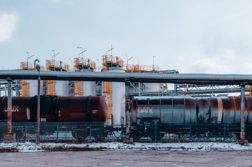 A winter scene of trains and industrial tanks in Trzebinia, Poland, highlighting the energy sector.