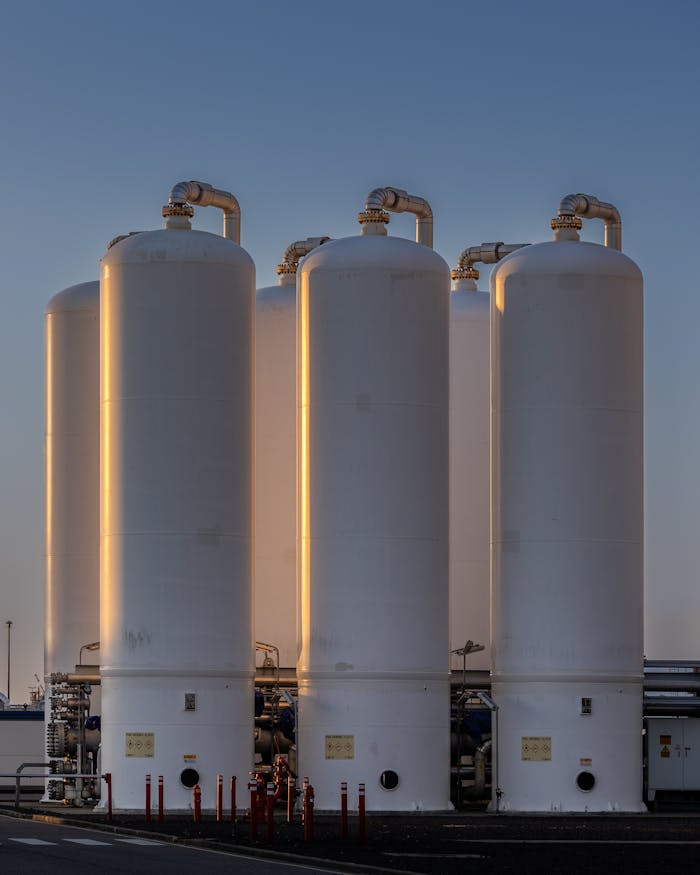View of industrial gas storage tanks illuminated by sunset light in Botlek, Rotterdam.